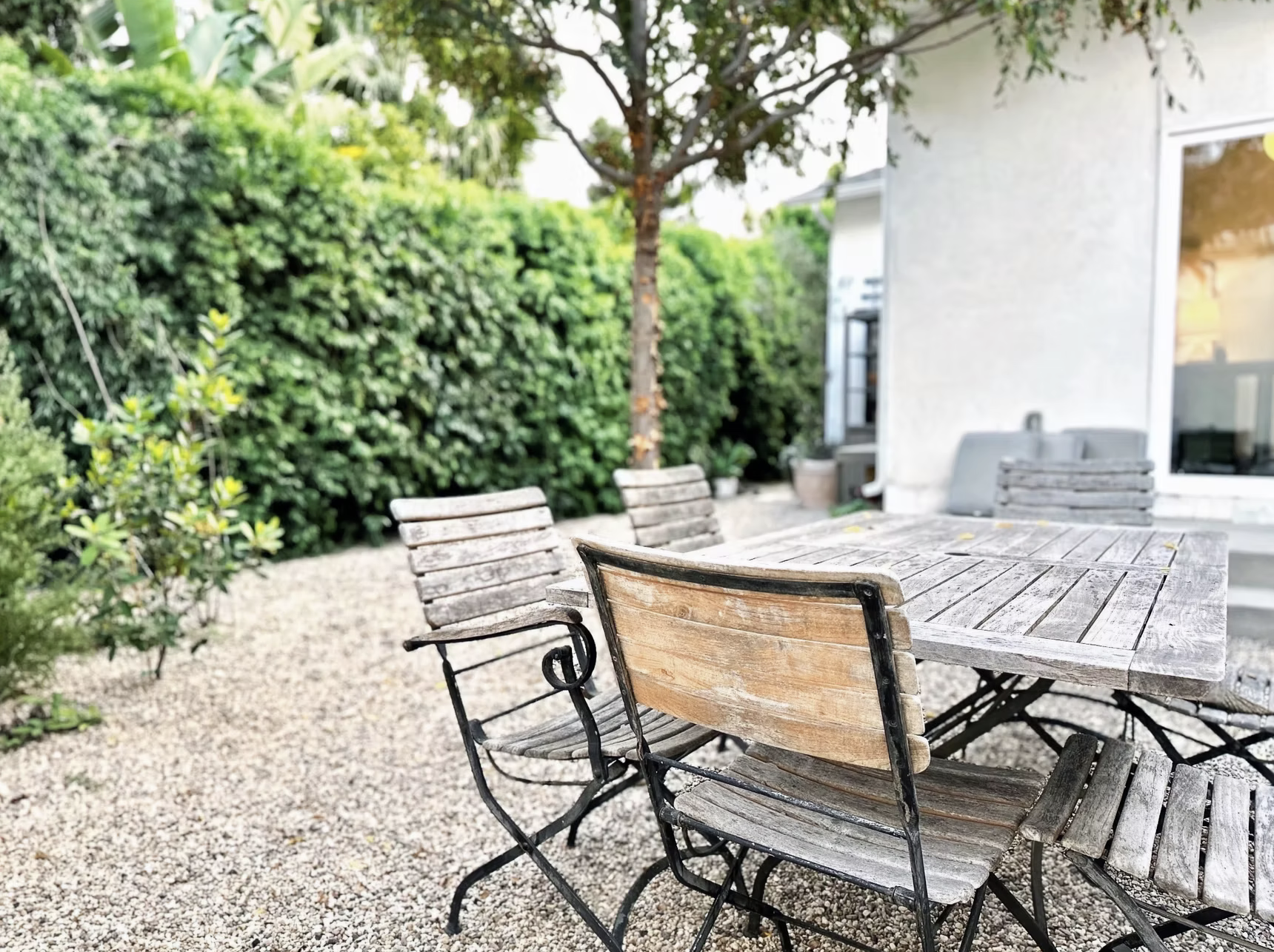 Outdoor dining area with gravel and native hedging